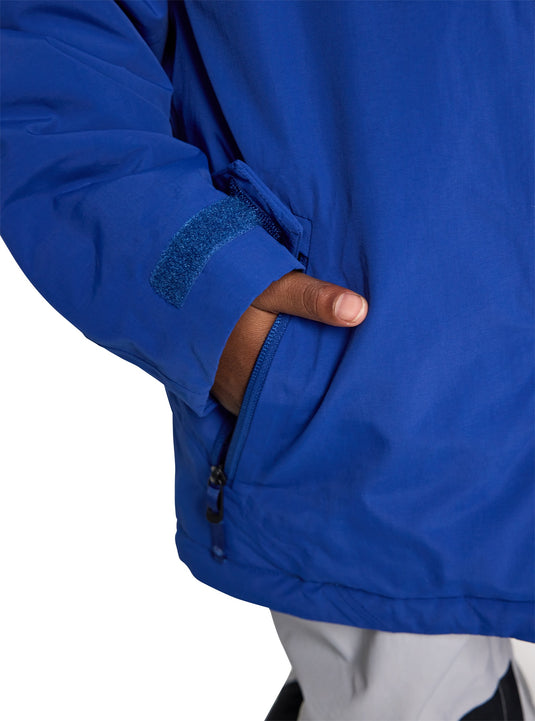 Close-up of a blue Burton jacket with a hand in the pocket on a white background