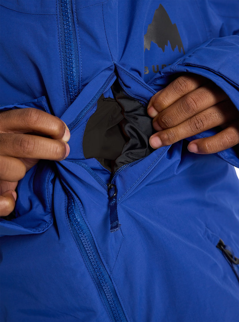 Load image into Gallery viewer, Close-up of a person adjusting the zip pocket of a blue Burton jacket with a logo.
