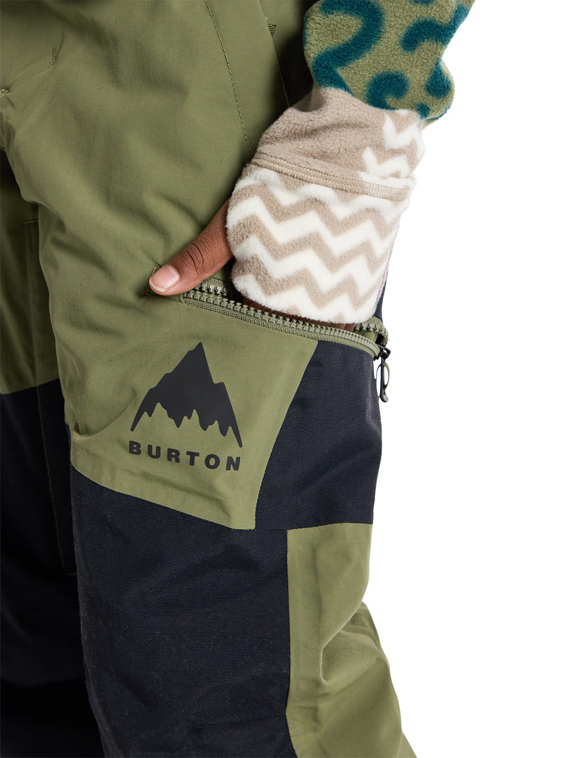 Load image into Gallery viewer, Close-up of a person wearing green and black Burton snow pants with a hand in a patterned glove.
