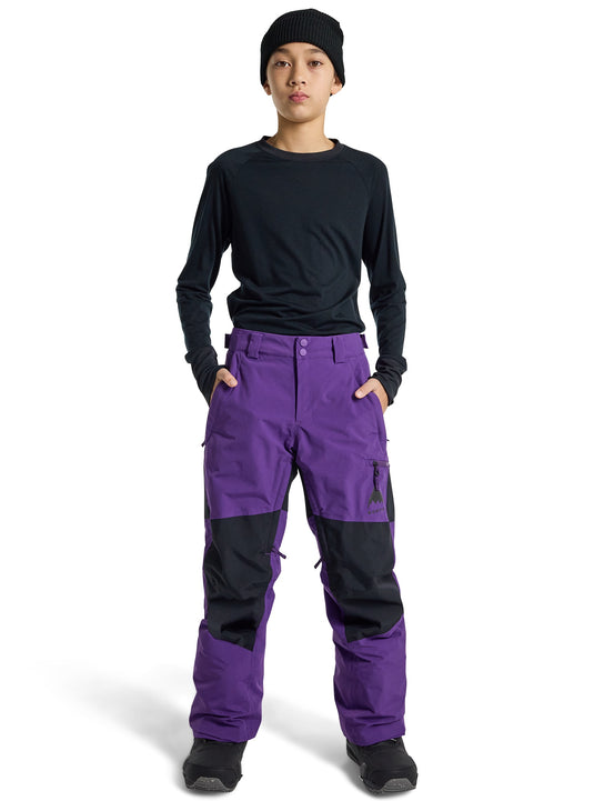 Person wearing a black long-sleeve shirt and purple snow pants on a white background