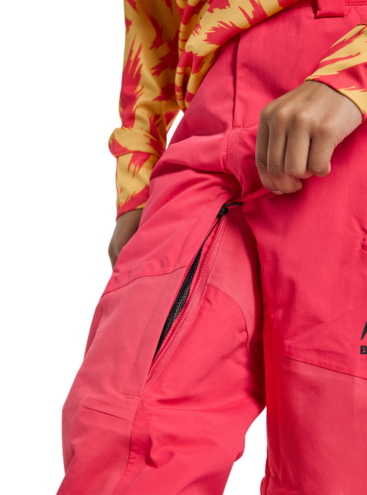 Person wearing a bright pink snow pants with a Burton logo on a white background