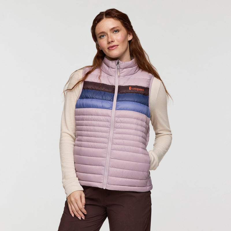 Load image into Gallery viewer, Woman wearing a multicolored puffer vest with Cotopaxi logo on a white background
