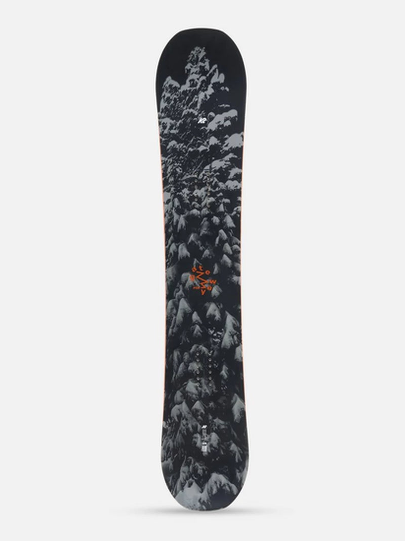 Load image into Gallery viewer, A K2 Gateway Pop snowboard shown from the top side, featuring a dark black background with a detailed graphic of snow-covered pine trees in white and gray, accented with a small orange logo in the center.
